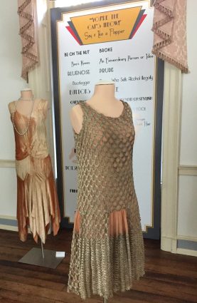 Gallery 5 - Flirty flapper dresses, like the one in front with gold thread mesh overlay, and the rear one with a dropped waist and handkerchief hemline, are on display.