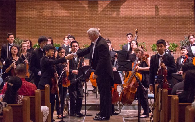 Piotr Gajewski, the National Philharmonic’s music director and conductor, shakes hands with Senior String Institute student Justin Park.