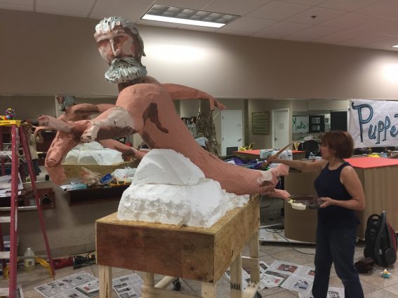 Event organizer Dan Thompson built the dollies and made the figures on the Narcissistine Chapel float. His daughter and her friends helped with some of the papier-mâché, and after he primed it, they are finishing the painting.