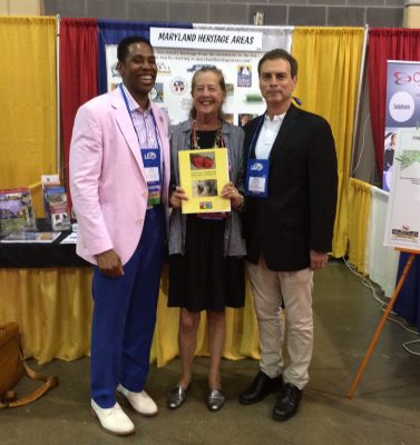 From left, Montgomery County Councilmember Craig Rice, Heritage Montgomery Executive Director Sarah Rogers and District 15 State Senator Brian Feldman at the 2017 Maryland Association of Counties Conference display Heritage Montgomery’s new “African American Heritage Cookbook”.