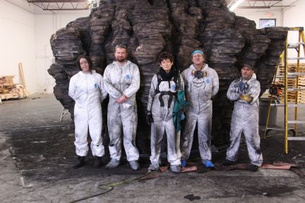 The sculptor Ursula von Rydingsvard, center, surrounded by studio assistants in front of “Bowl With Folds” (1998-99) in Detroit in 2017. (Kevin Silary/Galerie Lelong & Co.)
